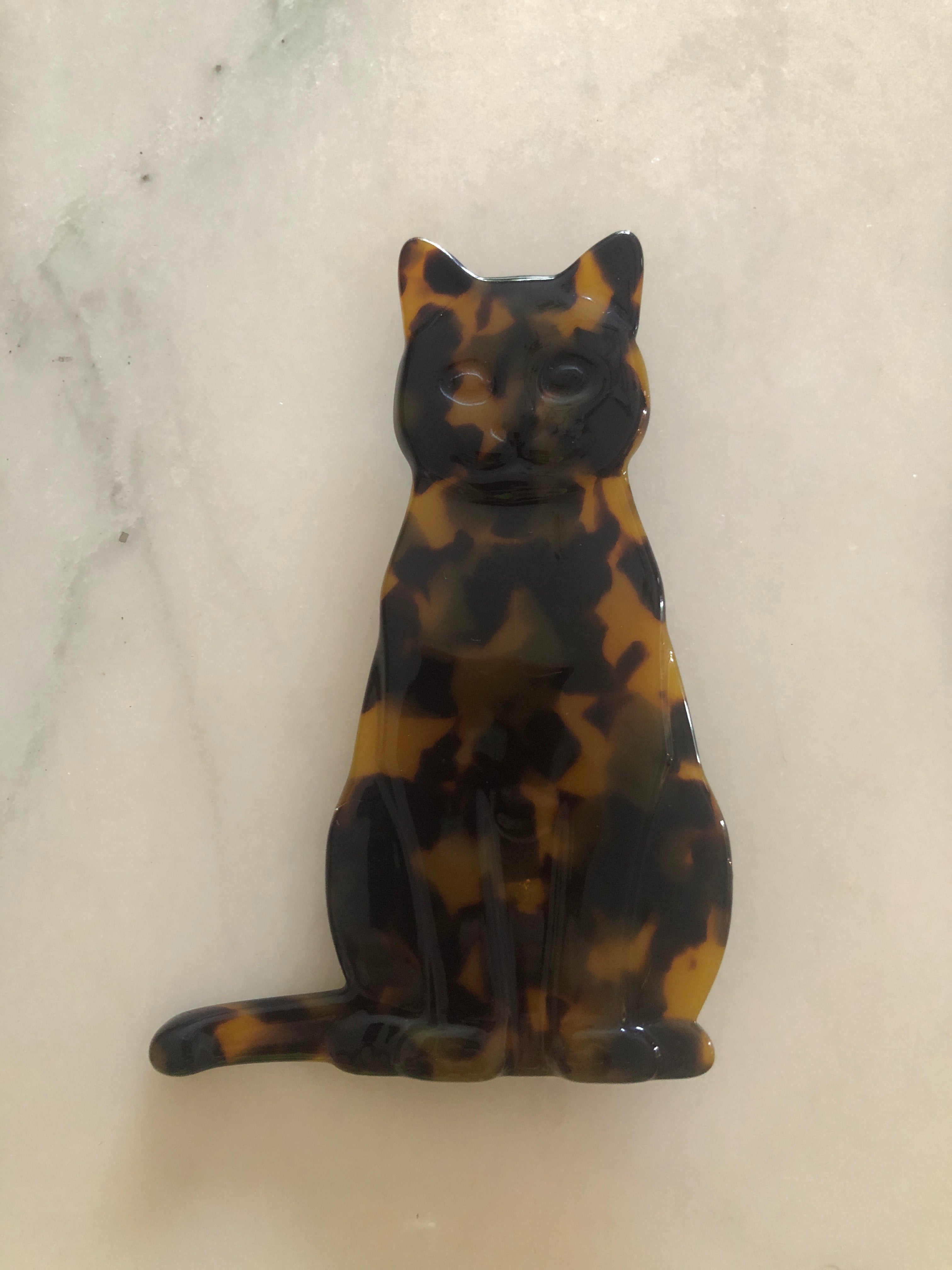 Men's cat brooch in brown tortoiseshell acetate. On a white marble background