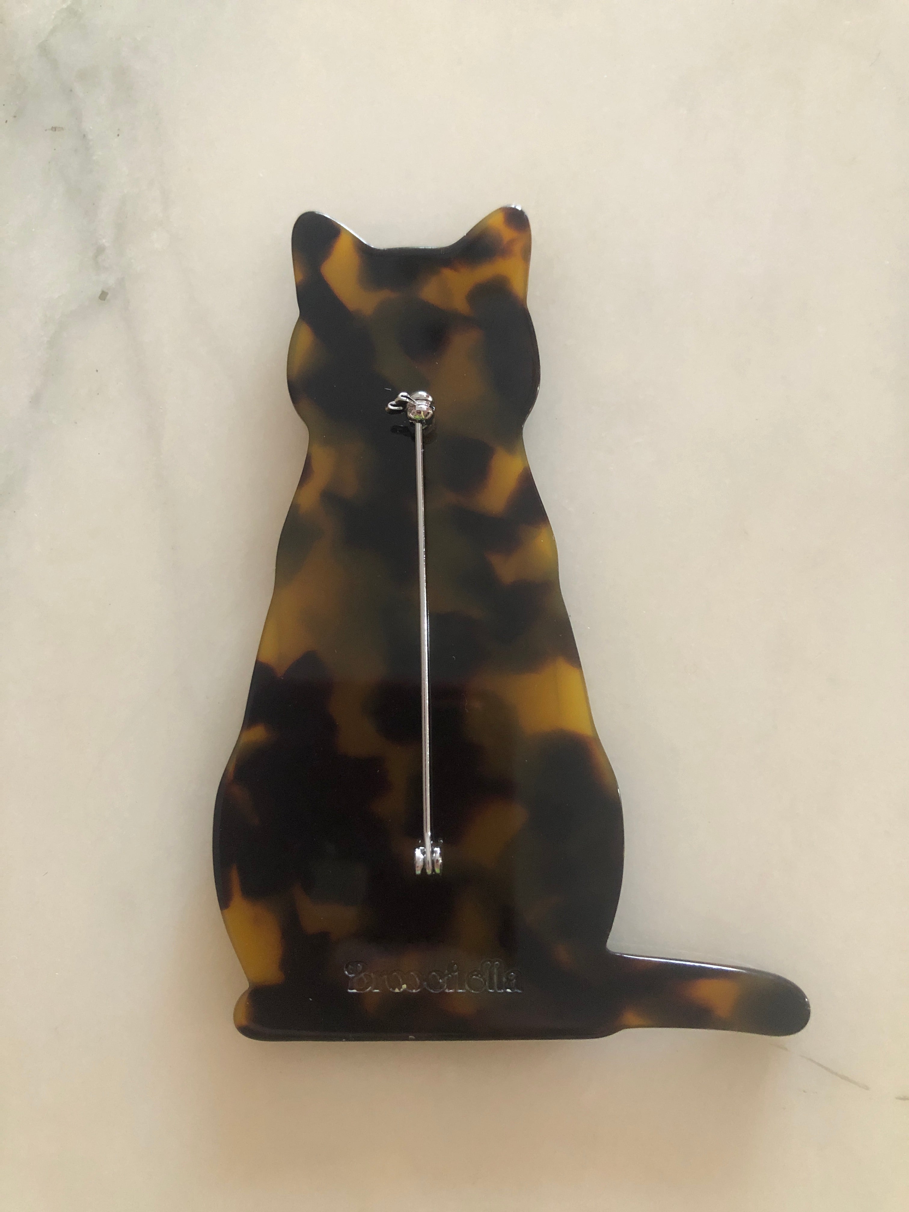 Men's cat brooch in brown tortoiseshell acetate. On a white marble background