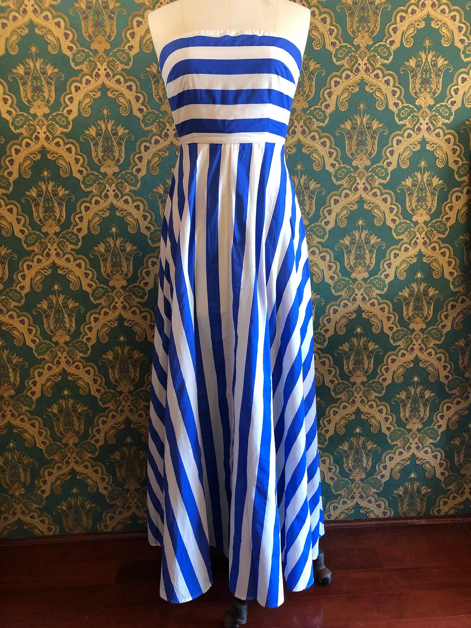 Broochella The Stylist's closet Aston Studio strapless cotton maxi dress in royal blue and white stripes, size AU 8, displayed on a dress form against a green and gold damask wallpaper background.