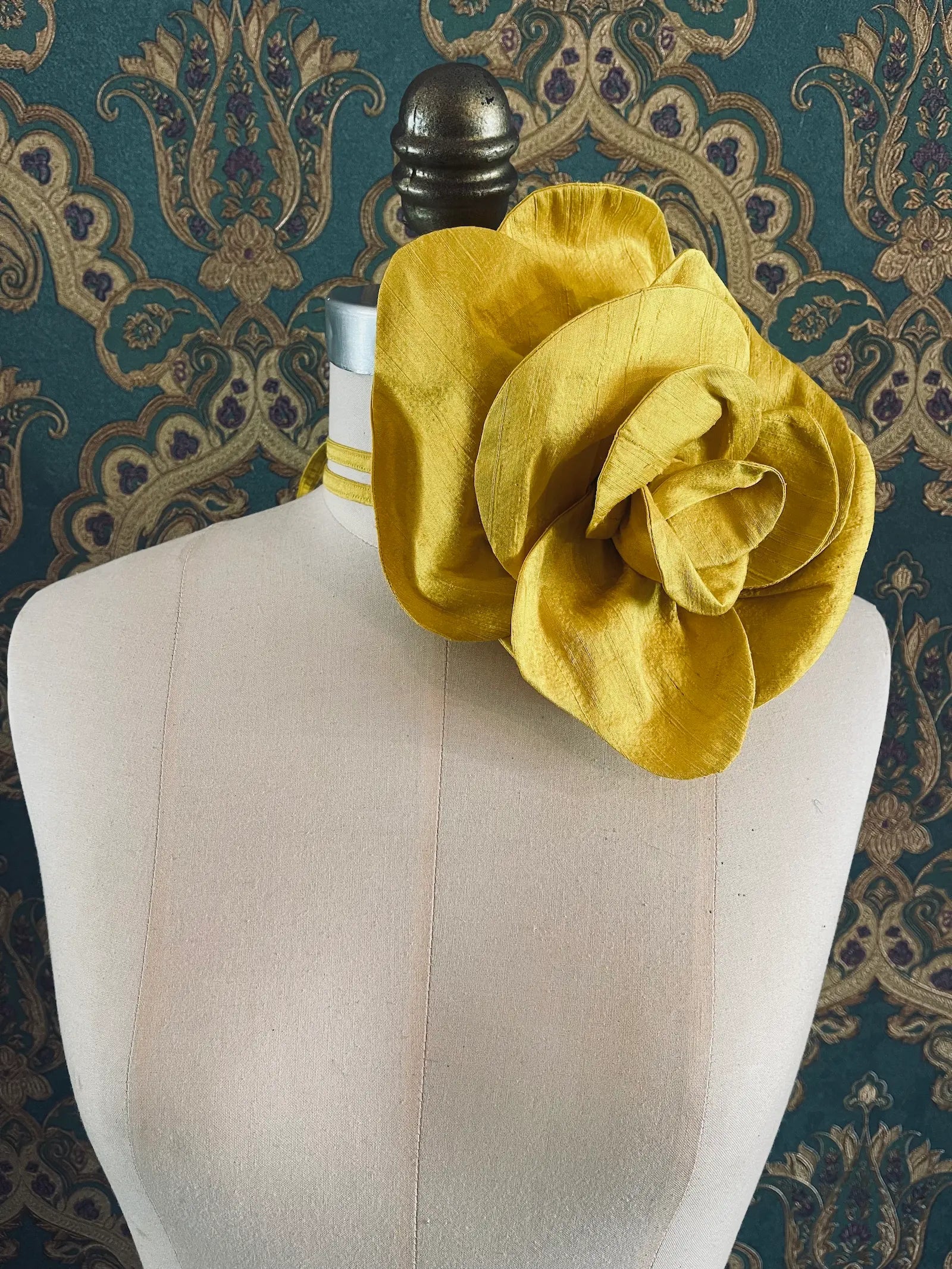 Broochella Bellucci large yellow handmade silk flower brooch and choker  Pictured on a mannequin. The background is green and gold damask wallpaper.