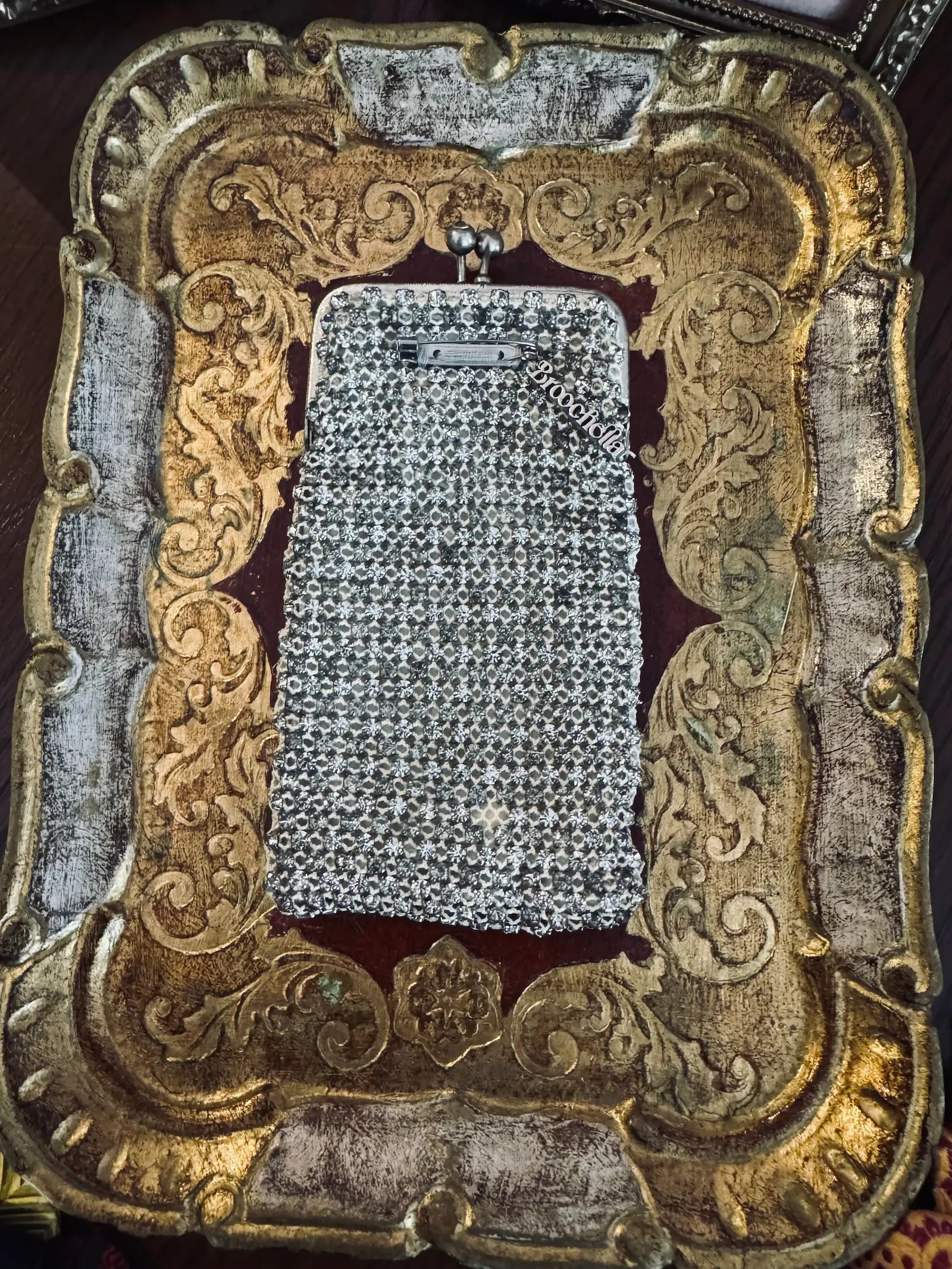 Mannequin wearing a black coat with a sparkling handbag and white shirt with decorative collar. It is wearing the Broochella Borsellino vintage crystal purse brooch. 
