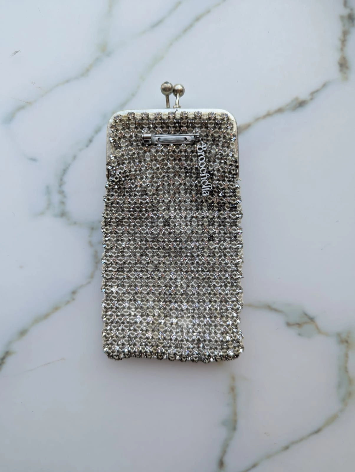 Mannequin wearing a black coat with a sparkling handbag and white shirt with decorative collar. It is wearing the Broochella Borsellino vintage crystal purse brooch. 