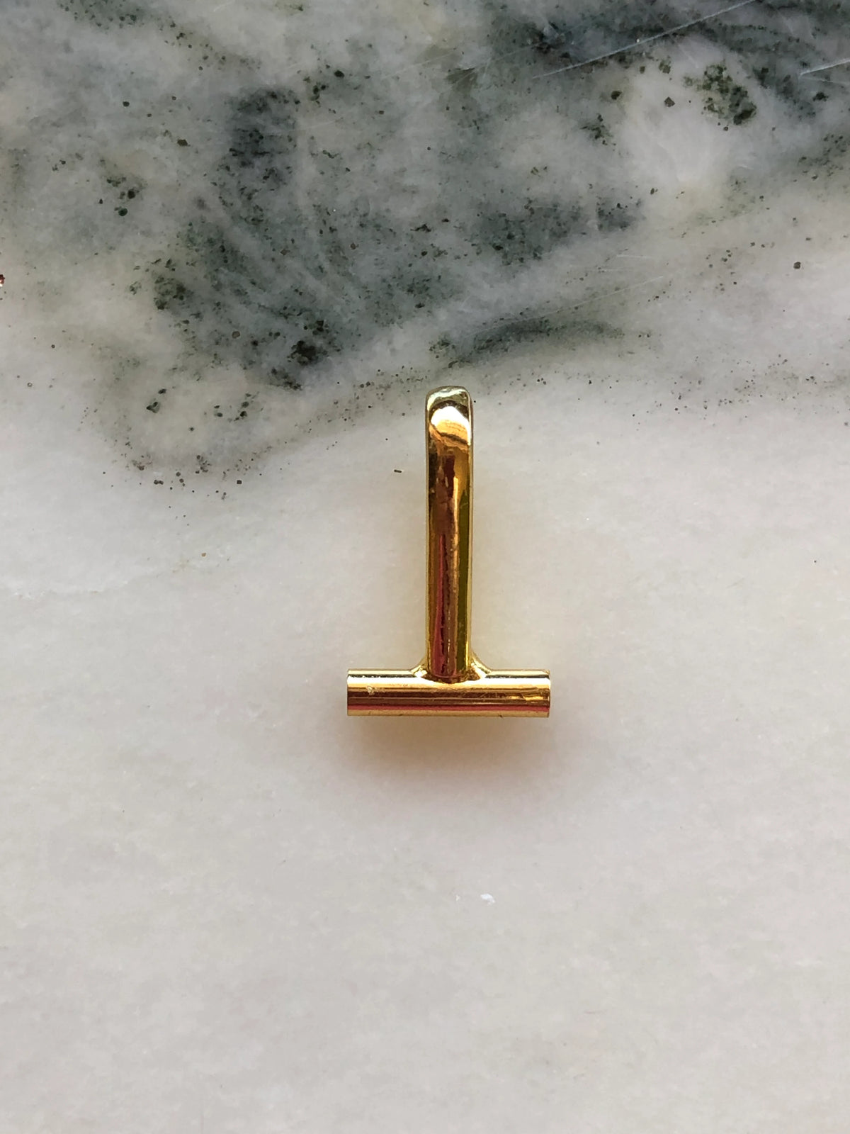 Broochella Brooch-to-Necklace Converter Horizontal in polished gold, photographed on a white and grey marble background.