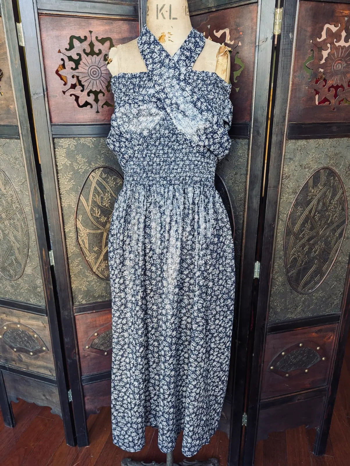 Broochella ciao lucia! blue floral midi dress on a mannequin in front of an ornate wooden screen