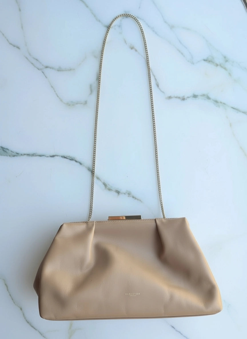 Broochella The Stylist's Closet De Mellier designer brown leather bag. Pictured on a white marble surface