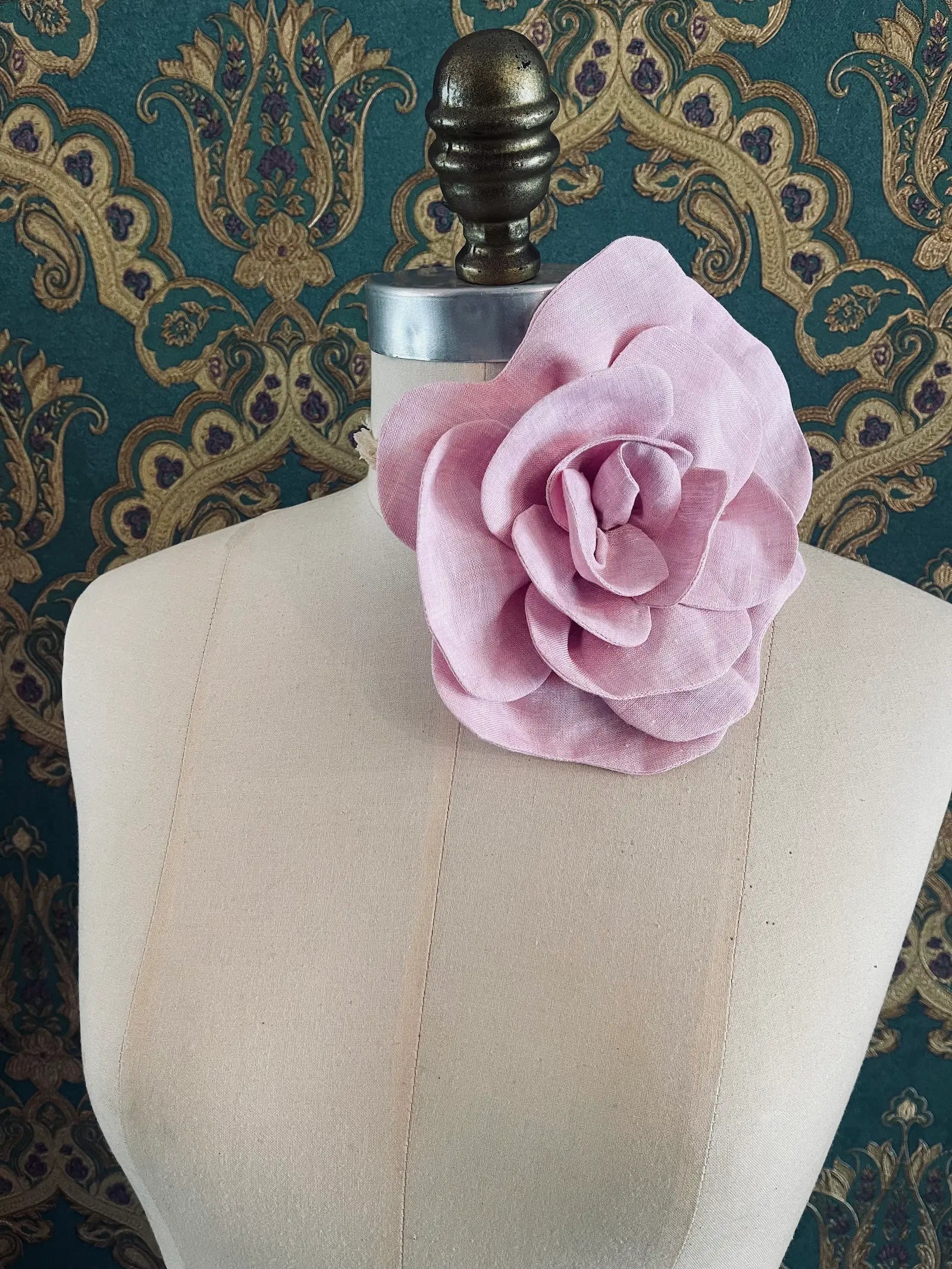 Broochella Florella large pink handmade linen flower brooch and choker  Pictured on a mannequin. The background is green and gold damask wallpaper.