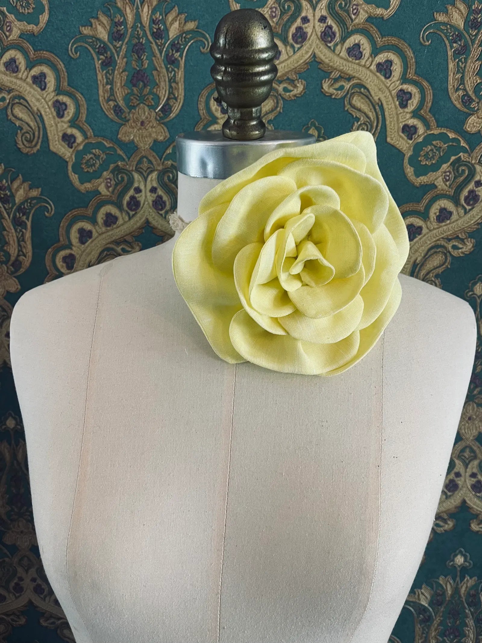 Broochella Florella large yellow handmade linen flower brooch and choker  Pictured on a mannequin. The background is green and gold damask wallpaper.