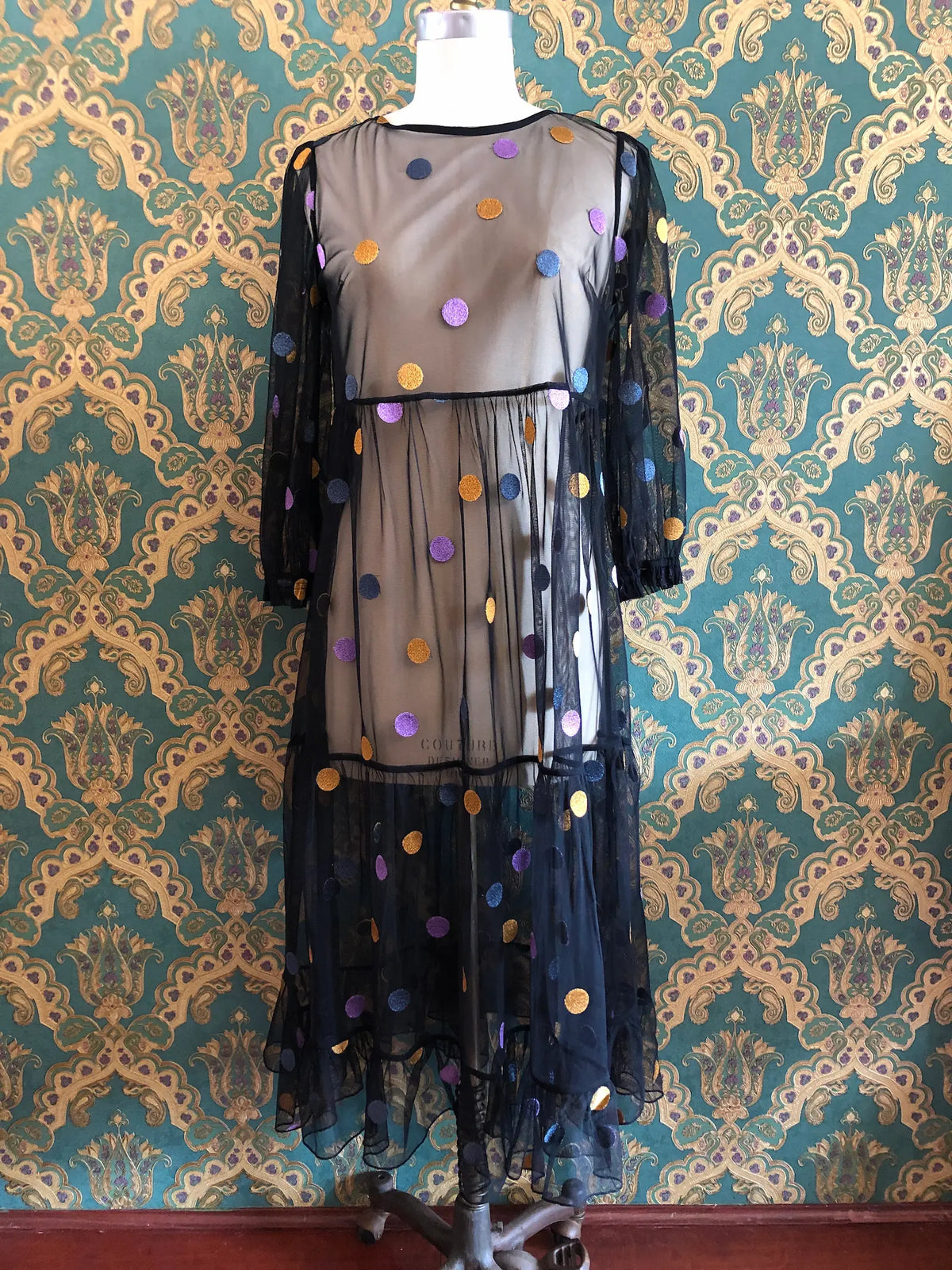 Broochella Gorman black mesh maxi dress with multicoloured metallic polka dots, long sleeves and a flowing layered hem, size AU 8. Pictured on a mannequin against green and gold damask wallpaper.