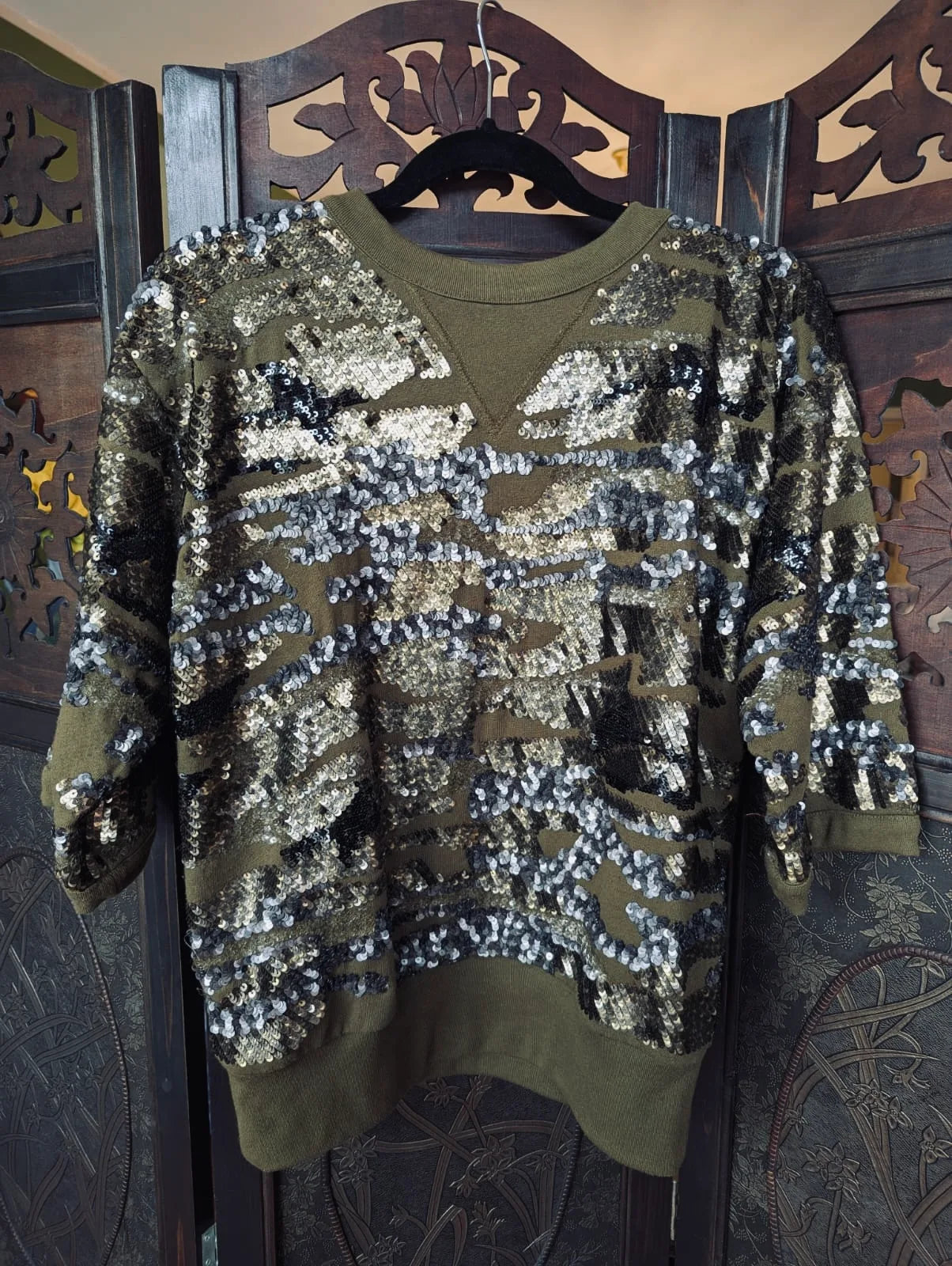 Broochella Isabel Marant Green Sequin Jumper- 38. Pictured hanging over an ornate dark wook room divider