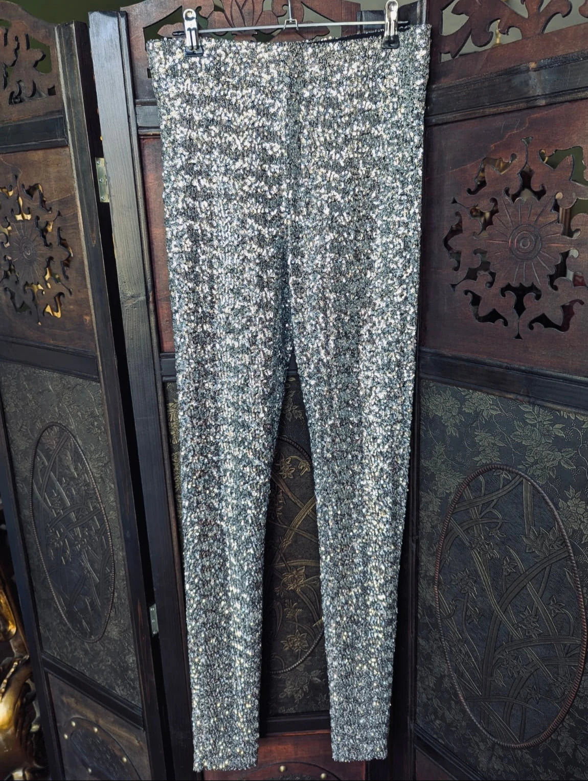 Broochella Isabel Marant Silver sequin pants hanging against a decorative wooden background