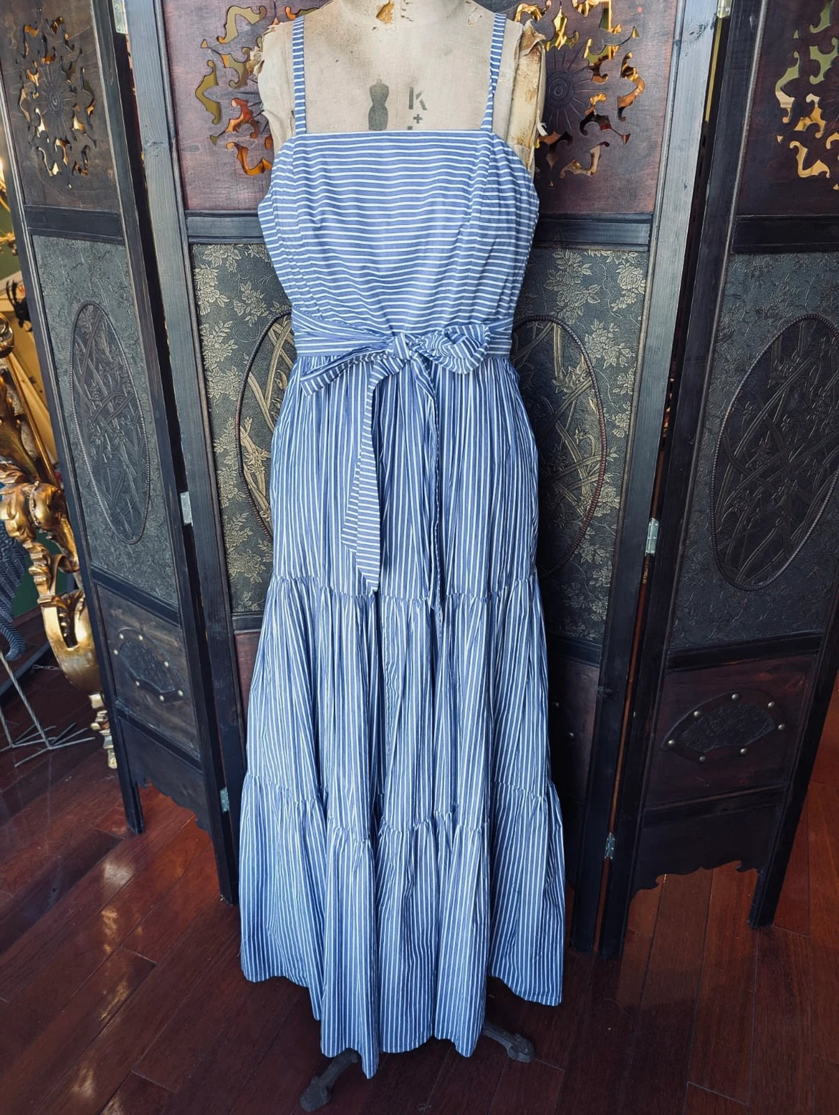 A Broochella J Crew Blue and white, cotton, striped maxi dress on a mannequin against a decorative wall.