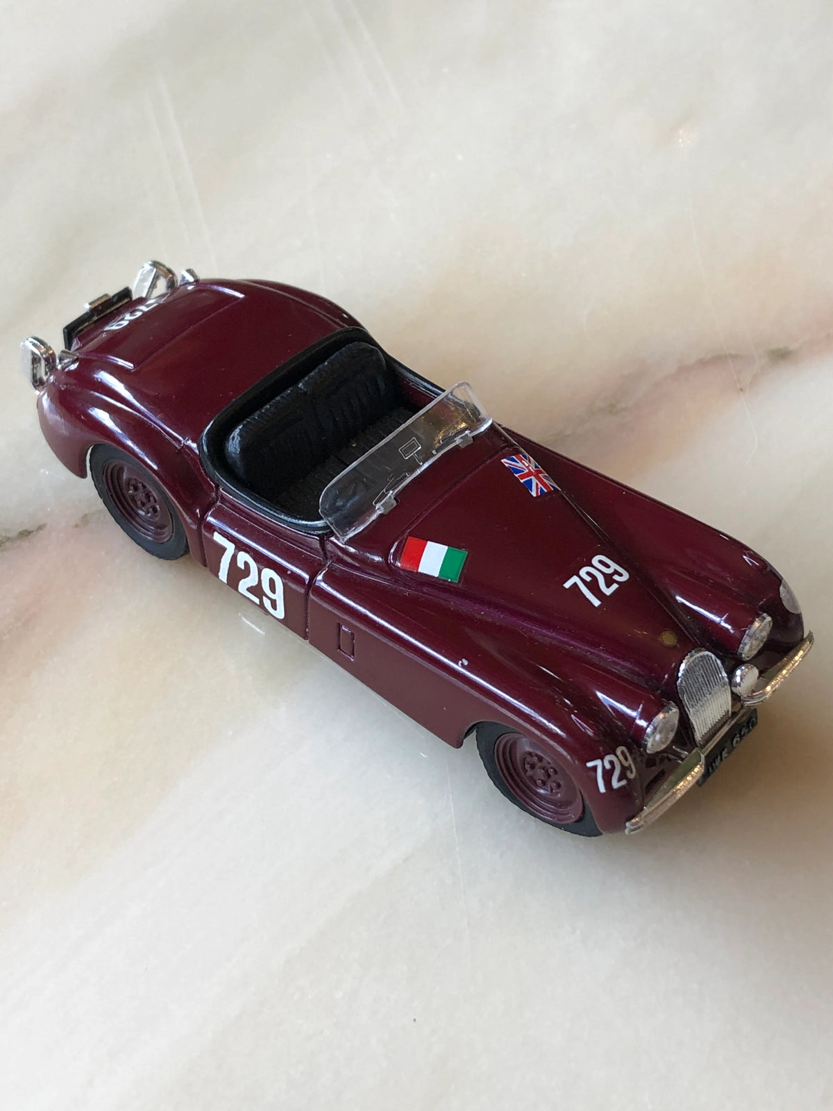 Broochella Men's Barolo No.729 Vintage Racing Car Brooch in deep burgundy, featuring an open-top cockpit, black leather-look seats, number 729 racing decals, British and Italian flags, and silver chrome detailing.