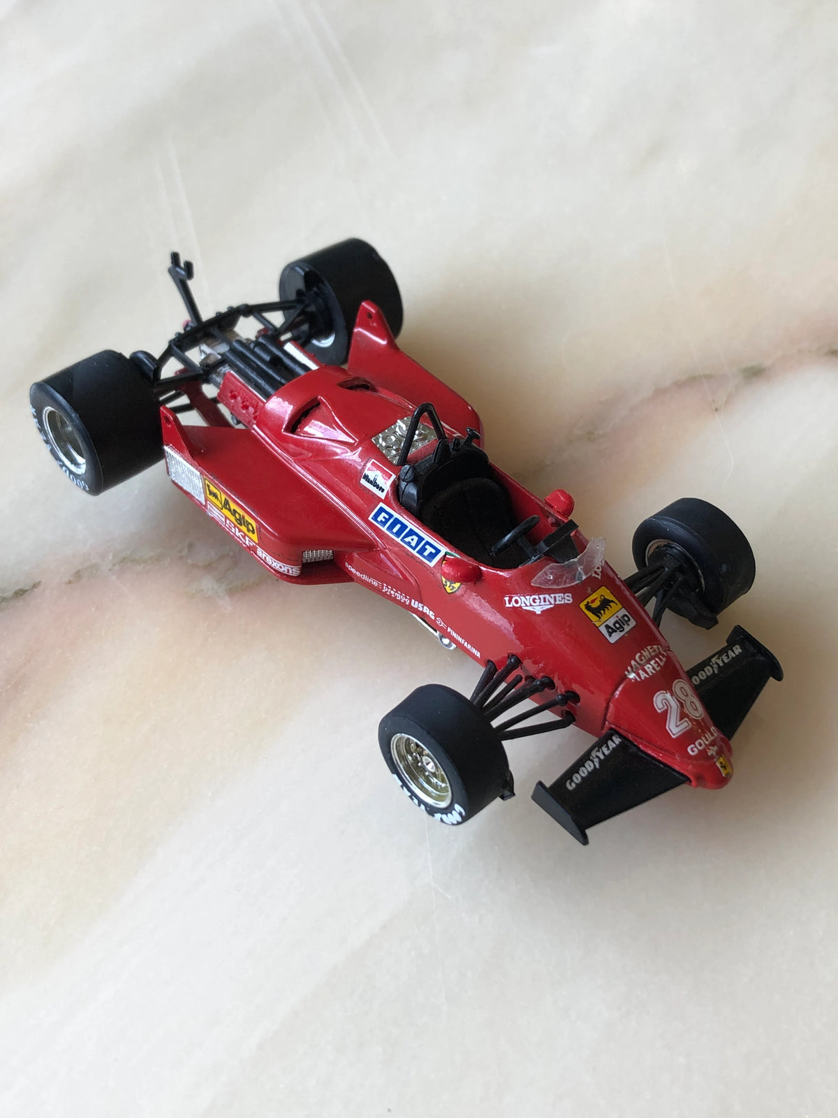 Broochella Men's Rosso Monza No.28 Ferrari Formula One Racing Car Brooch in red, featuring an open cockpit, black racing tyres, Goodyear front wing, Ferrari emblem and vintage FIAT and Agip sponsor decals.