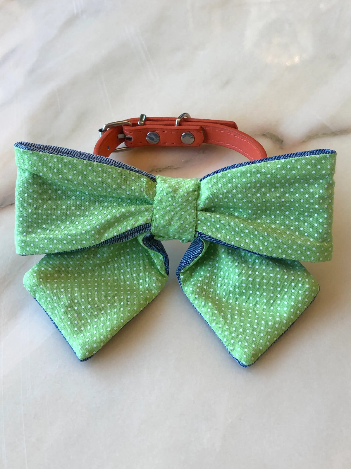 Broochella Poochella green and white polka dot cotton dog bow with contrasting blue denim trim, displayed with a coral orange adjustable pet collar and silver-tone hardware.