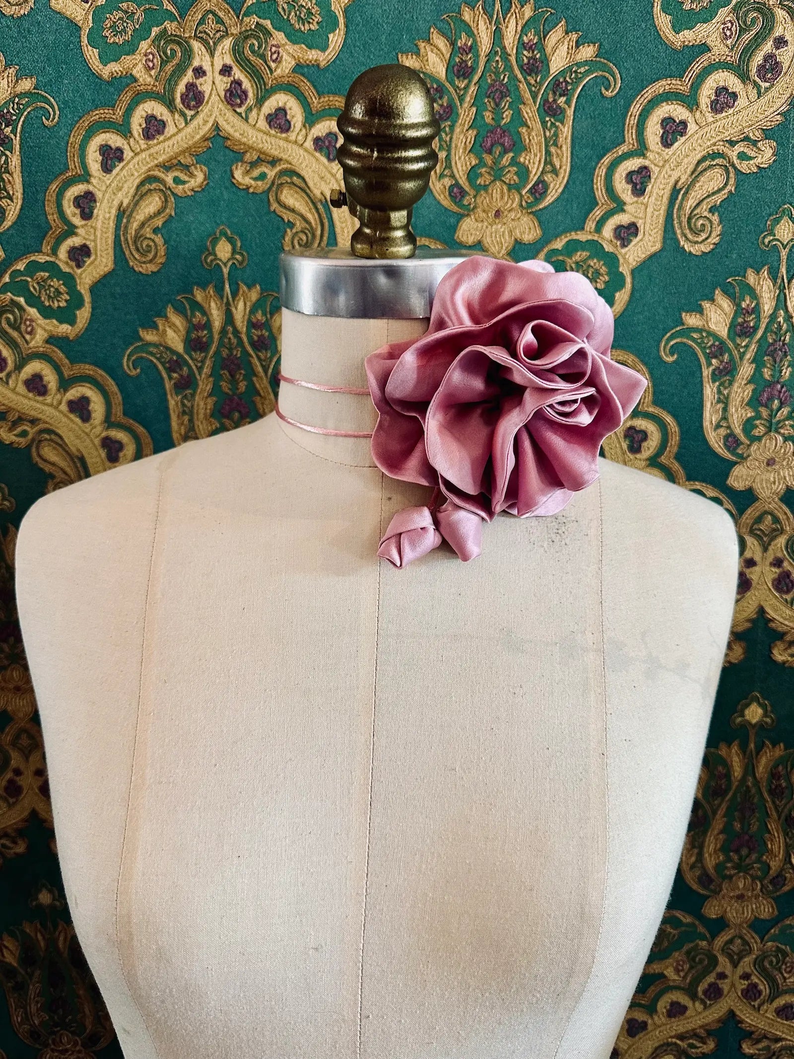 Broochella Rosetta pink handmade silk satin flower brooch and choker  Pictured on a mannequin. The background is green and gold damask wallpaper